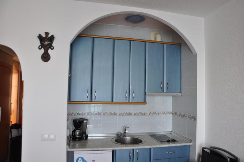 a kitchen with blue cabinets and a sink at Studio Vue Mer in Torremolinos