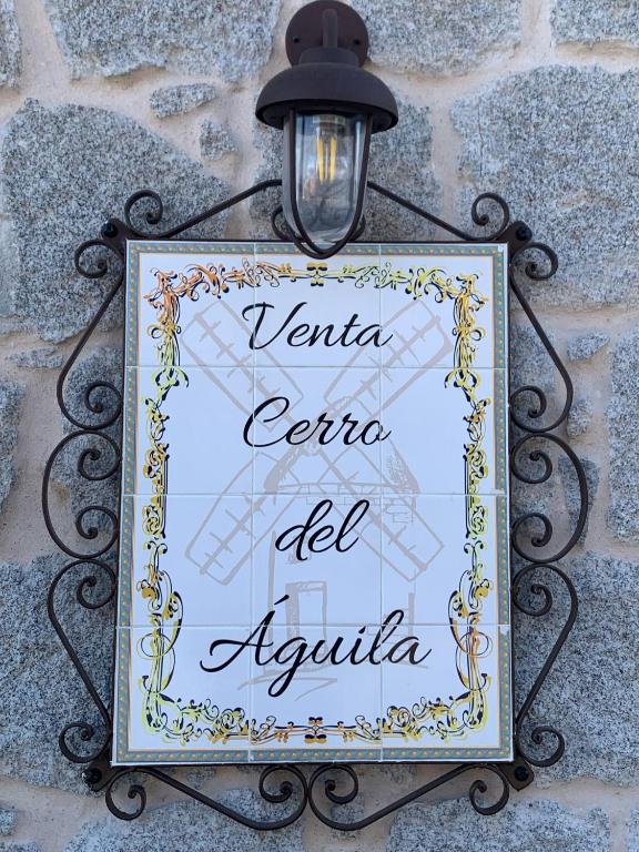 a sign attached to a wall with a light at Venta Cerro del Águila in Ventas con Peña Aguilera