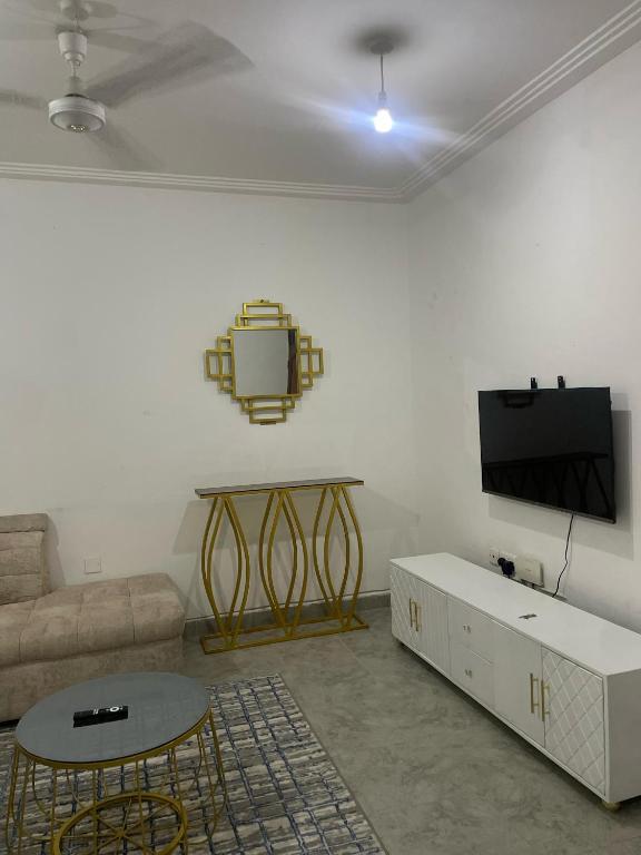 a living room with a couch and a tv at Bliss Residence Bamburi Mwembeni in Mombasa
