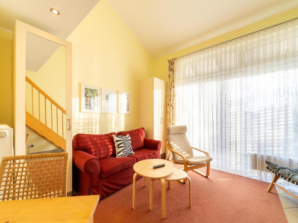 a living room with a red couch and a table at Ideale Familienwohnung in der Natur in Granzow