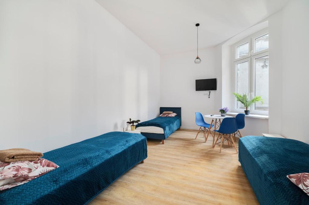 una sala de estar con dos camas y una mesa en Centrum 2 Łódź 7 Próchnika21, en Łódź