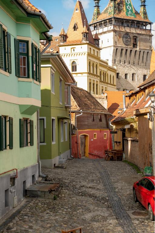 a city street with buildings and a clock tower at Stradela in Sighişoara