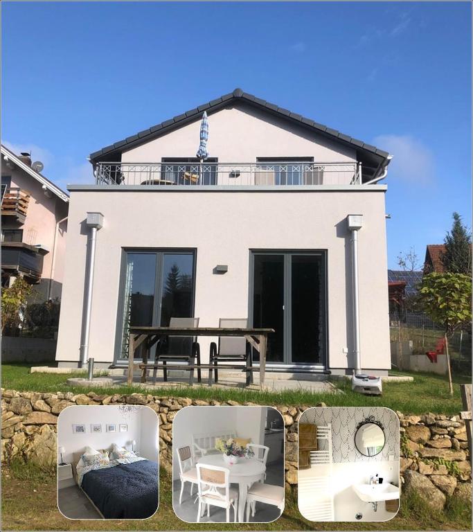a house with a table and chairs in front of it at Apartment mit Blick ins Grüne in Mitterfels