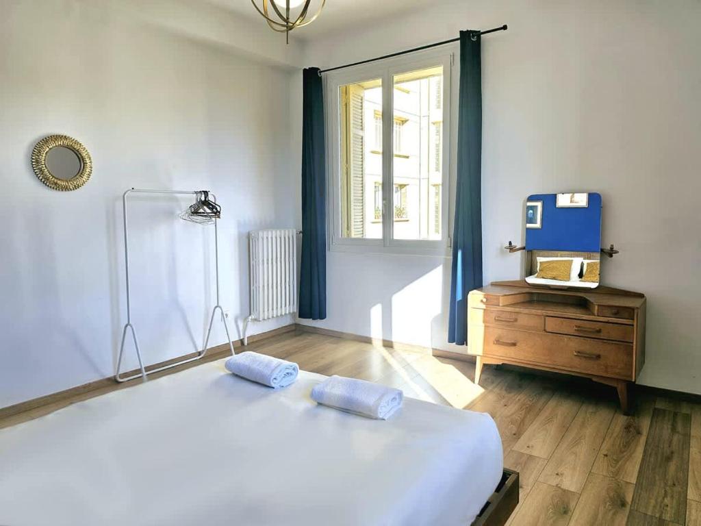 une chambre avec un grand lit blanc et une fenêtre dans l'établissement Seduisant 3 chambres avec vue sur le Vieux-Port et proche du Panier, à Marseille