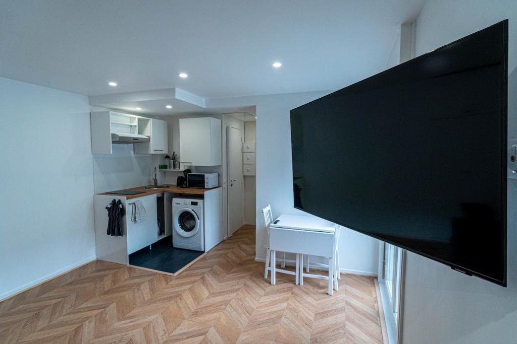 un salon avec une grande télévision à écran plat noir dans l'établissement Little Sacré-Coeur Nest !, à Paris