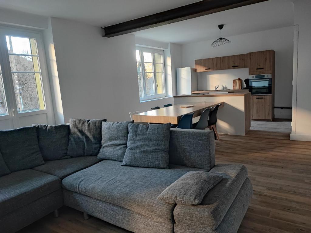 un salon avec un canapé et une cuisine dans l'établissement Nouveau sur Ax-les-Thermes, Grand appartement de 118m à 5 min du centre-ville, à Ax-les-Thermes