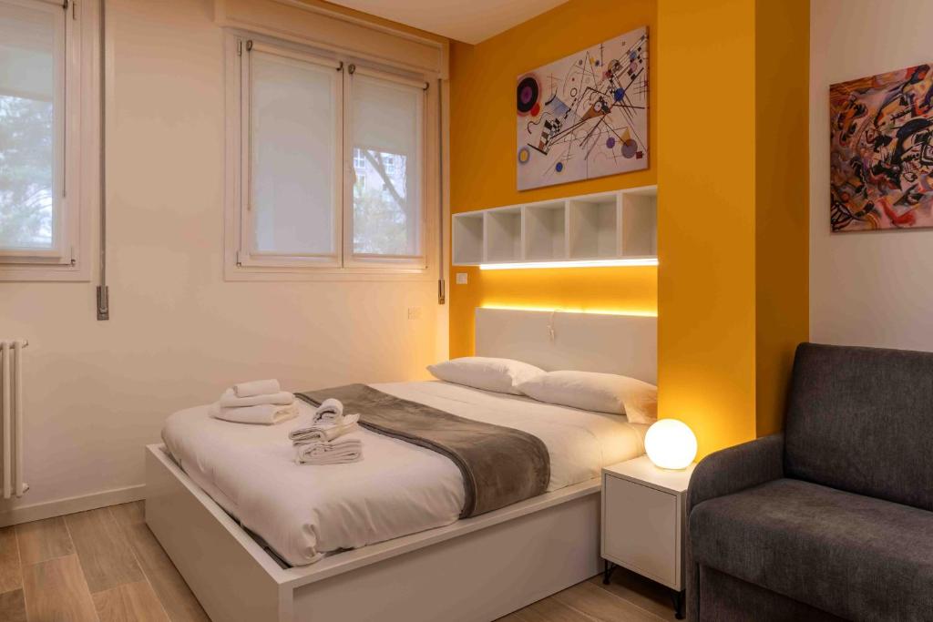 a small bedroom with a bed and a chair at Locami Bi-Apartments Padova in Padova