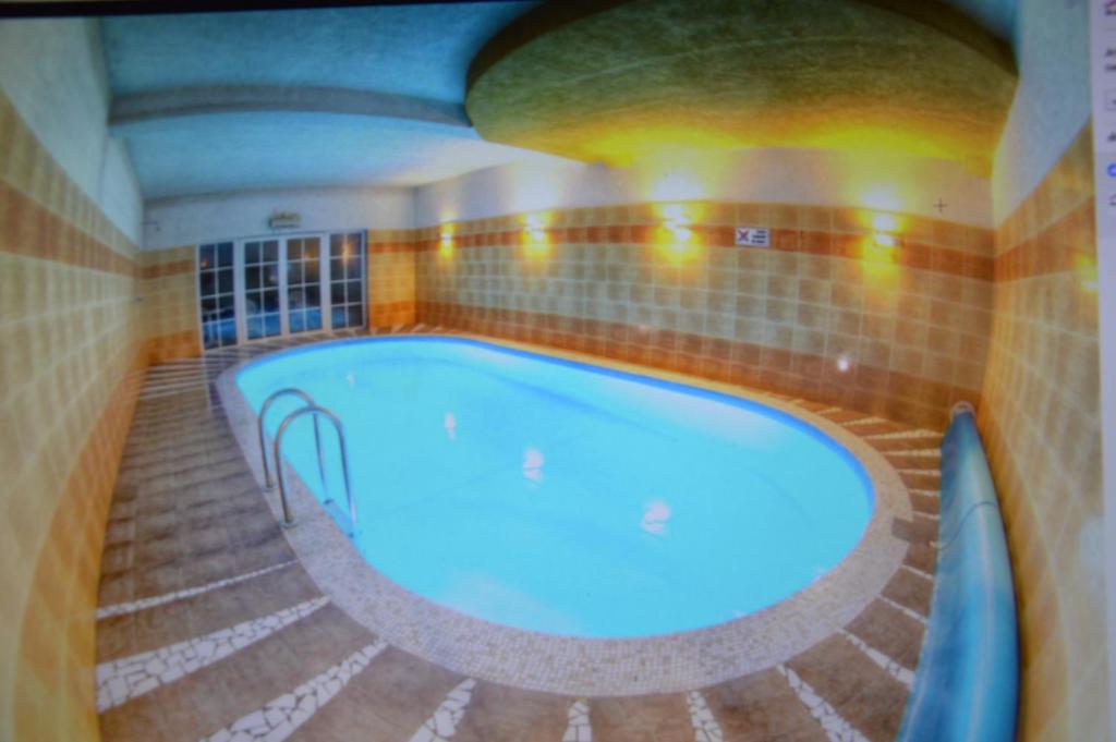 a large swimming pool in a room with a tiled floor at B&B Landrynka in Krynica Morska