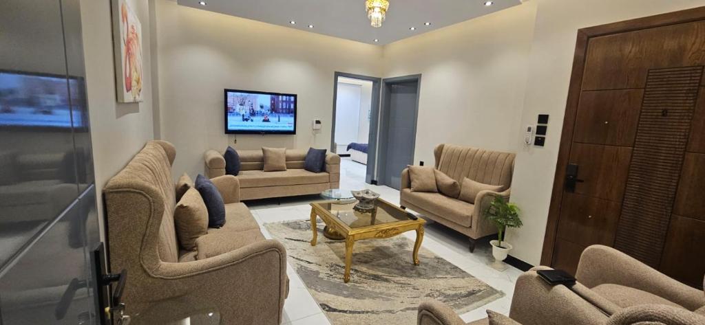 a living room with couches and a tv in it at Summo bilding in Jeddah