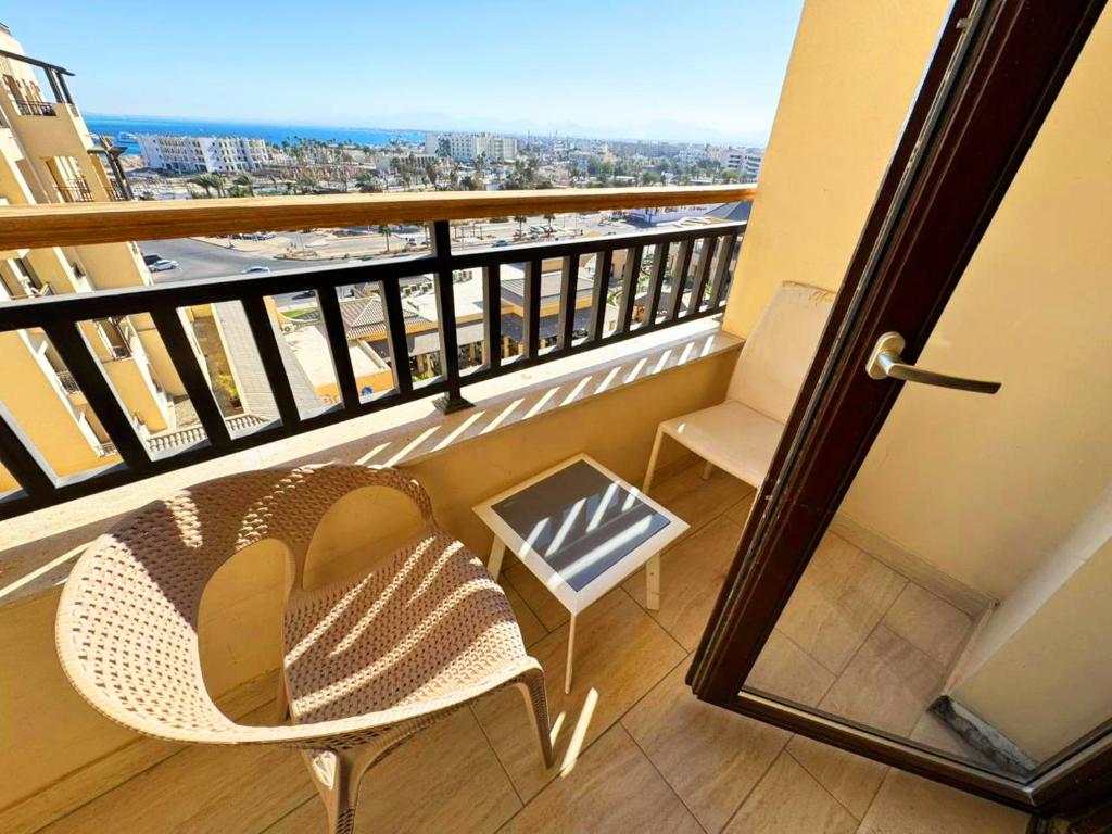een balkon met een stoel en uitzicht op de stad bij Apartment Aldau in Hurghada
