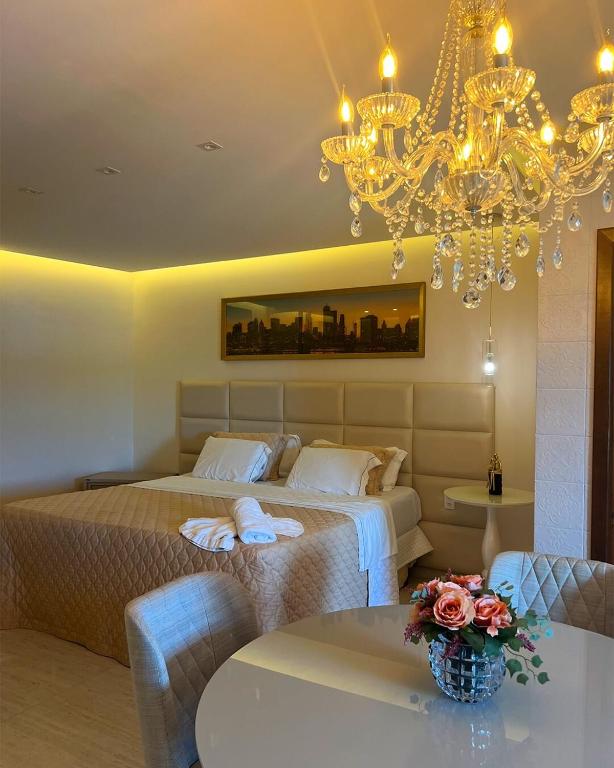 a bedroom with two beds and a chandelier at Amoras Hotel fazenda in Santo Antônio de Jesus