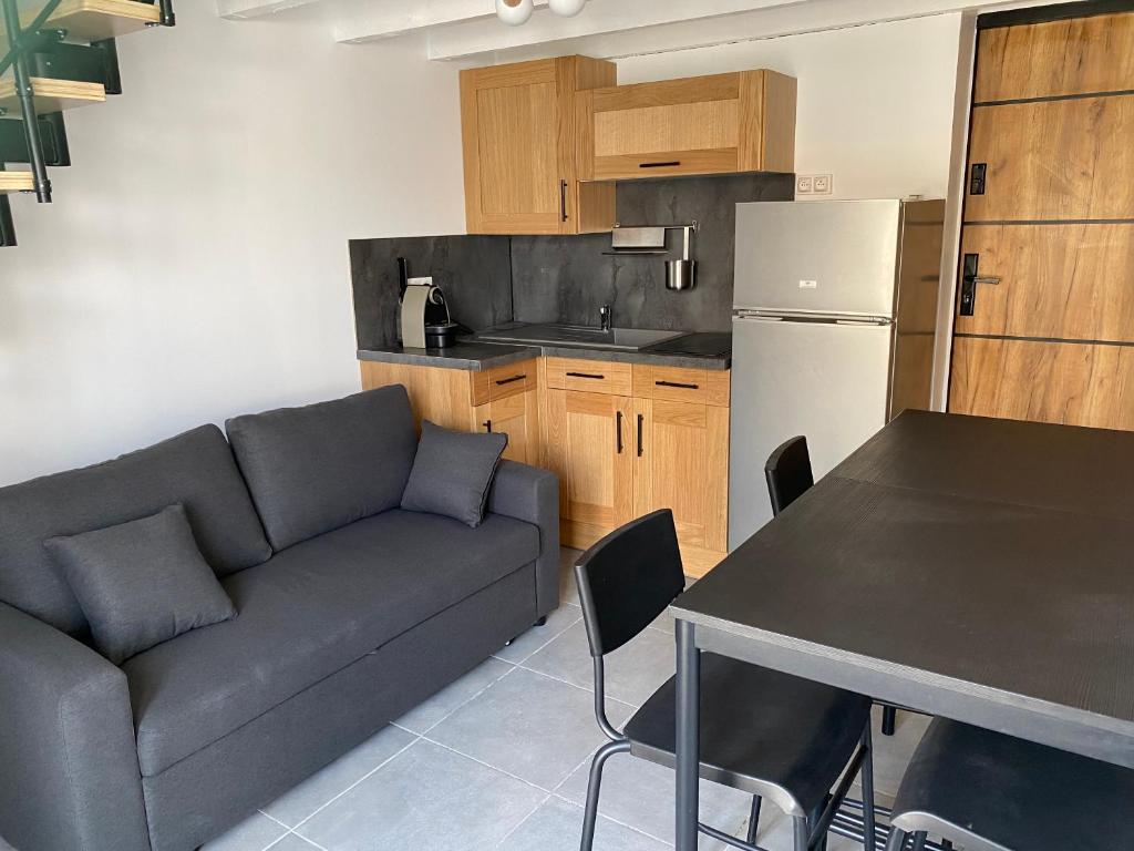 un salon avec un canapé et une table et une cuisine dans l'établissement Studio pour 2 personnes - Cossi, à Saintes-Maries-de-la-Mer