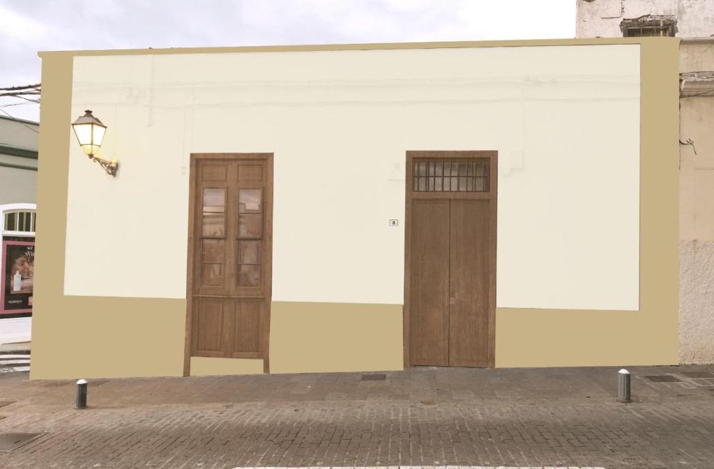 un edificio bianco con due porte sopra di Casita La Mercería a Güímar