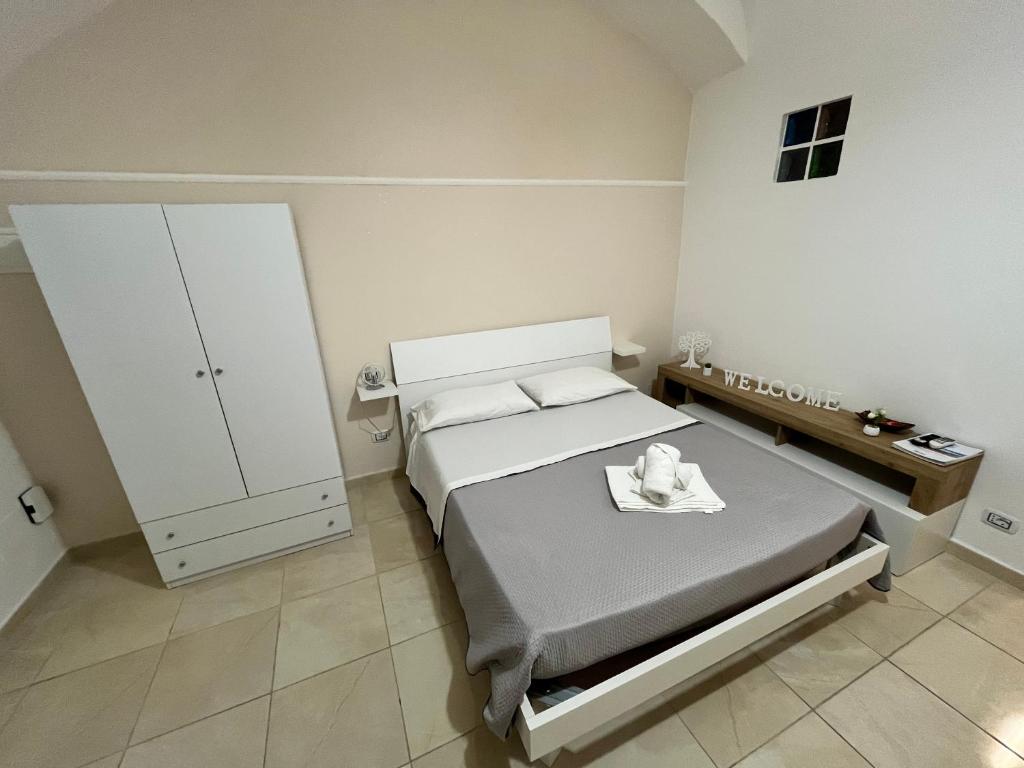 um pequeno quarto com uma cama e um armário em L'Albero della Vita em Catânia
