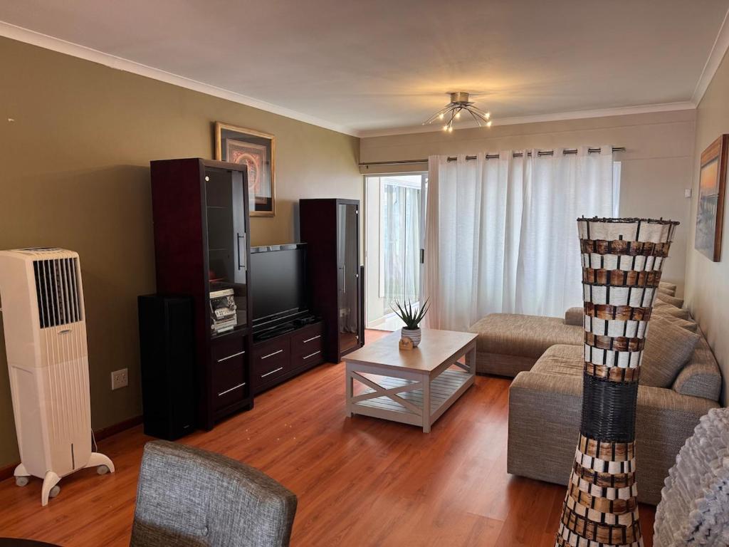 a living room with a couch and a tv at 2 Bedroom City Center Haven! in Swakopmund