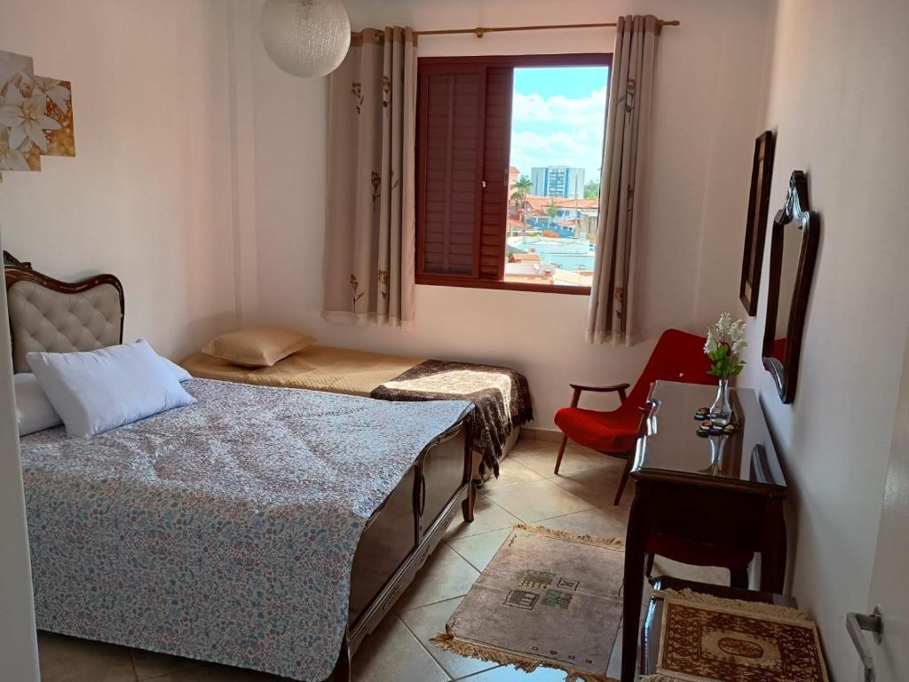 ein Schlafzimmer mit zwei Betten und einem Tisch und einem Fenster in der Unterkunft Aguas de Lindoia pertinho de tudo in Águas de Lindóia