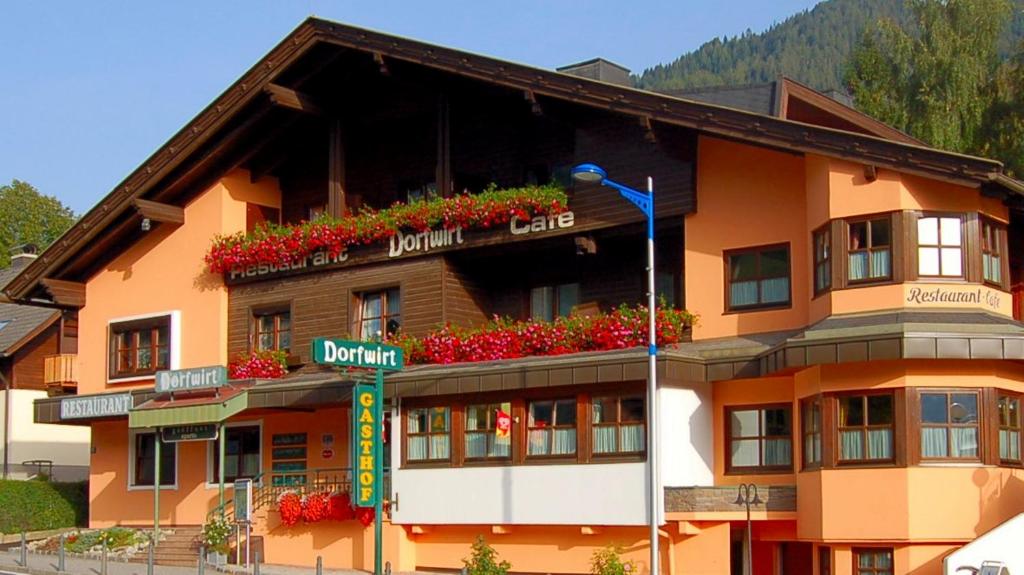 ein Gebäude mit Blumen auf der Seite in der Unterkunft Restaurant-Pension Dorfwirt in Bad Kleinkirchheim