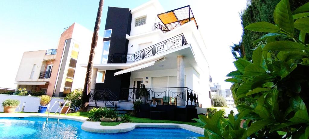 Un edificio con piscina enfrente. en Villa Dorada Beach Alicante, en Alicante