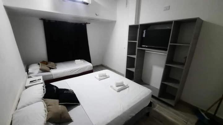 een kleine kamer met een bank en een tv bij Solano House in Termas de Río Hondo