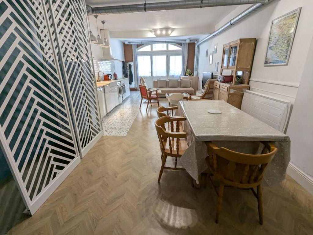 ラ・ロシェルにあるAppartement cosy et atypique RDC centre villeのテーブルと椅子のあるキッチンとリビングルーム