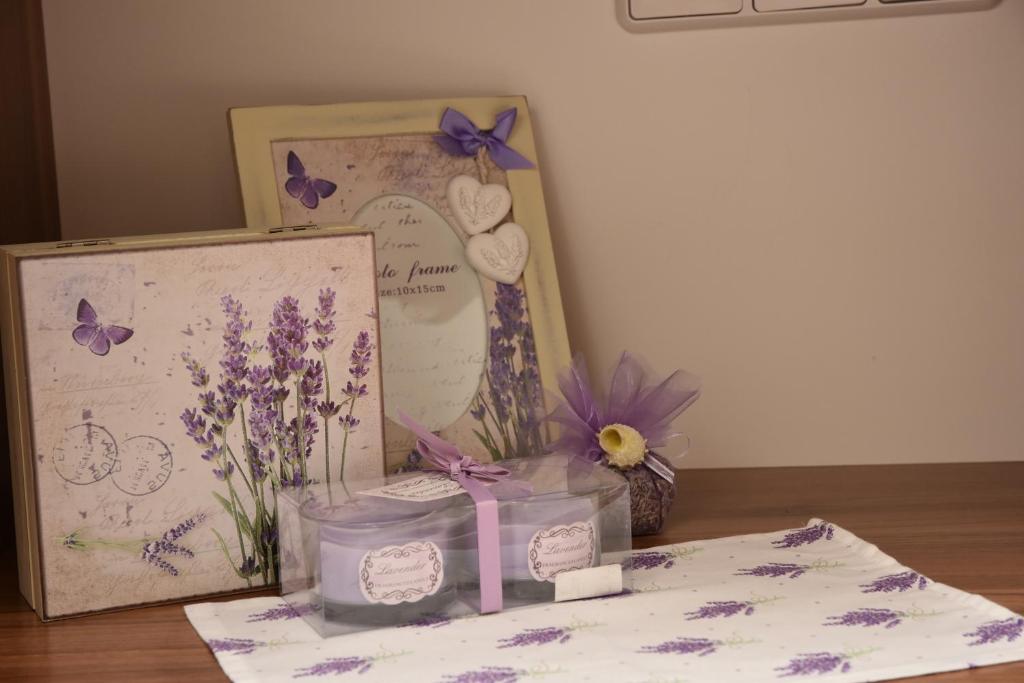 une table avec une photo et une boîte avec des fleurs violettes dans l'établissement Apartments Lavendula, à Vodice