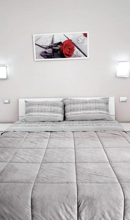 a white bedroom with a large bed and a picture on the wall at Tourist House Palermo in Palermo