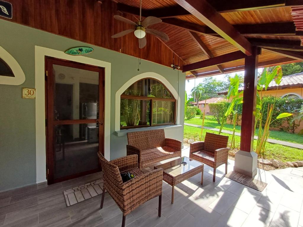 a patio with wicker chairs and a door to a house at Gray Beach House in Potrero