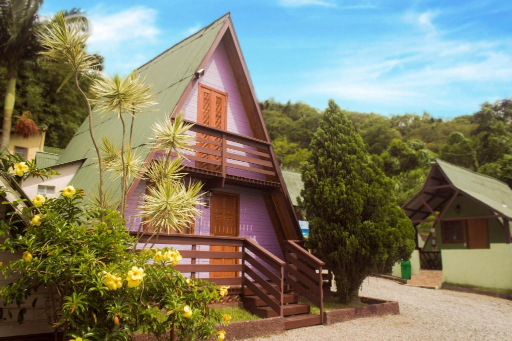 ein lila Haus mit einigen Pflanzen davor in der Unterkunft Pousada Ilha da Magia in Florianópolis