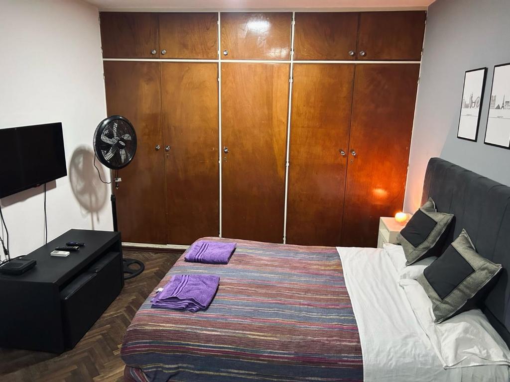 a bedroom with a bed and a dresser and a clock at Departamento ESPAÑA in Paraná