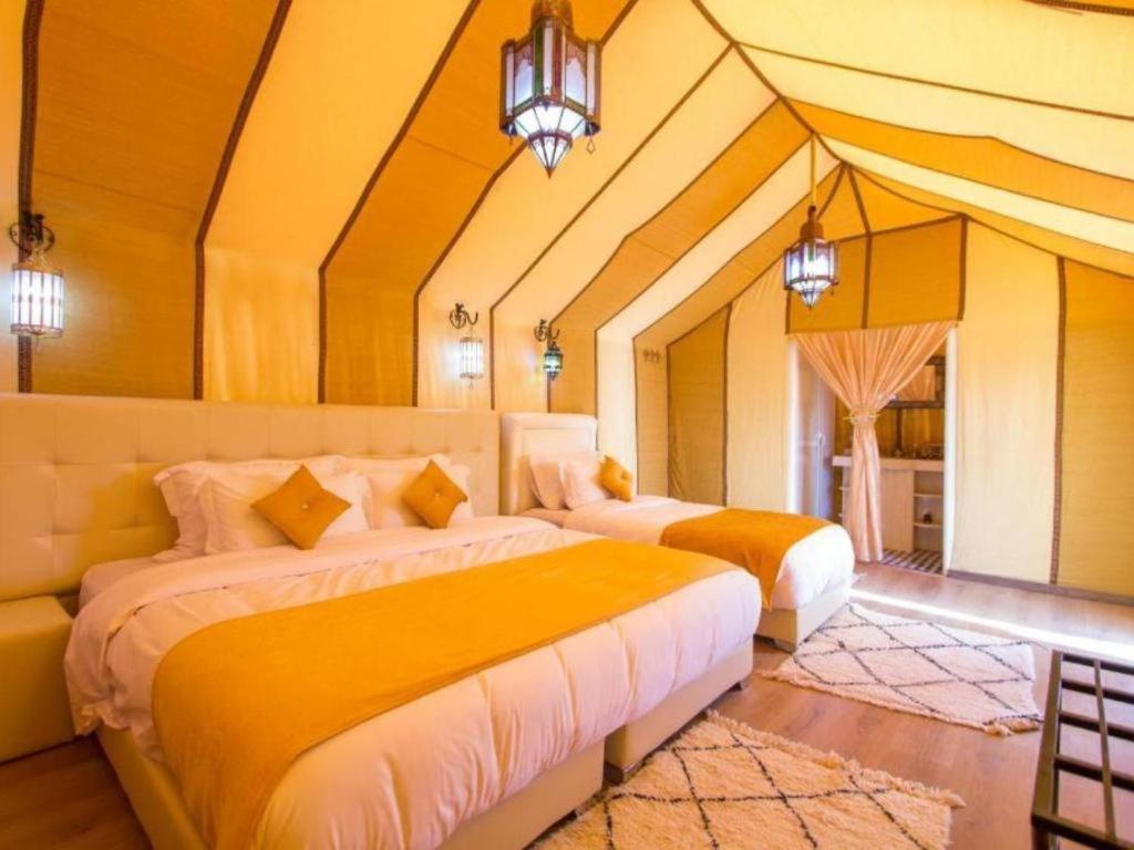 a bedroom with two beds in a room at Camel Experience Camp in Merzouga