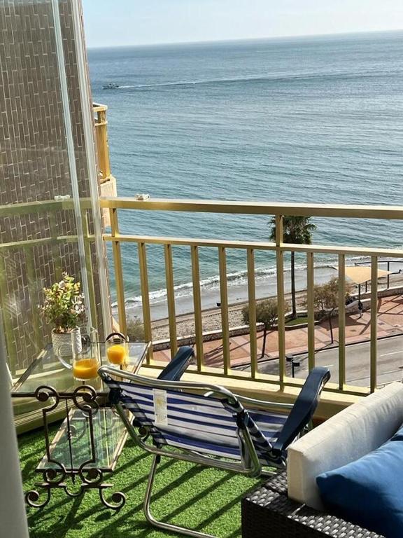 a bench sitting on a balcony overlooking the ocean at Fuengirola, Doña Sofia amazing sea view in Fuengirola