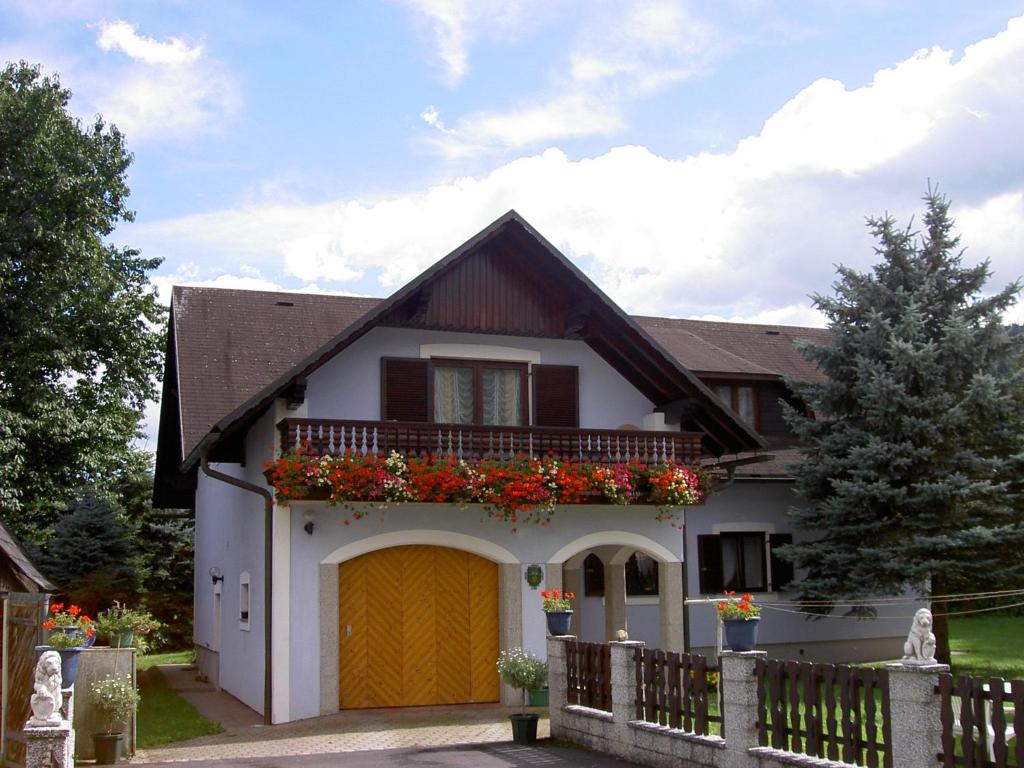 une maison avec un balcon fleuri dans l'établissement Ferienhaus Kleindienst, à Deutschlandsberg