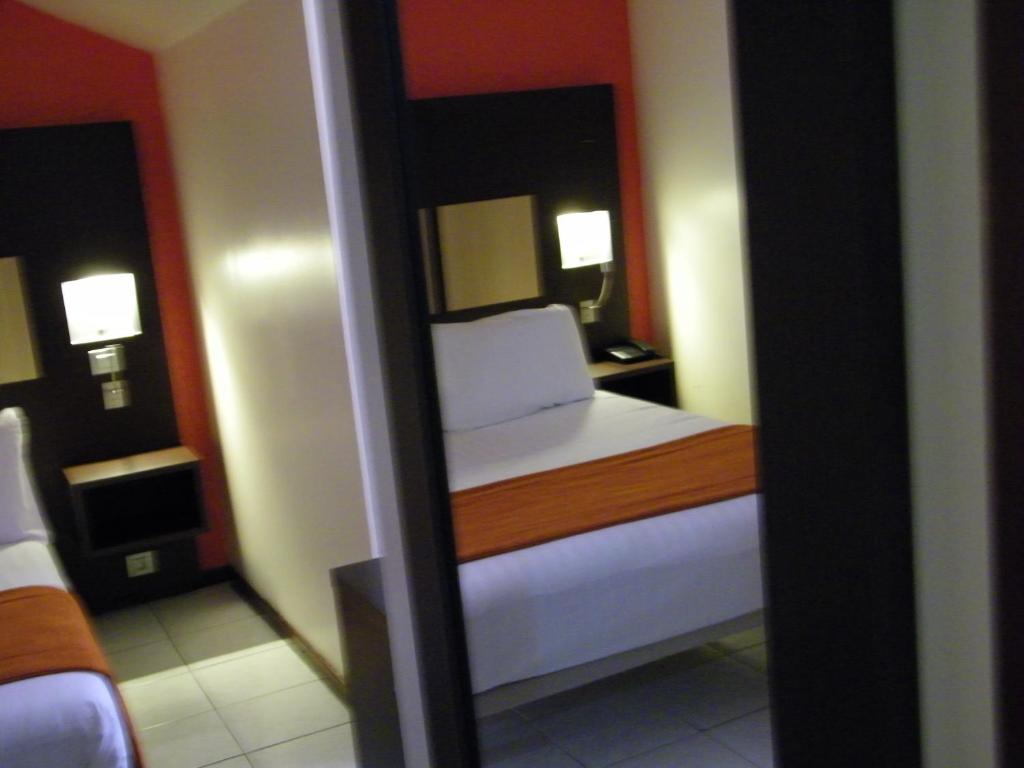 Postel nebo postele na pokoji v ubytování Central Hotel Cayenne