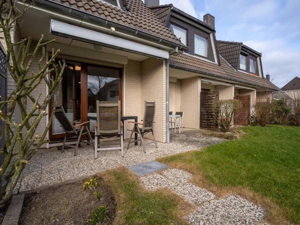 a house with chairs and a table in the yard at Ferienhaus in Büsum für 4 Personen in Büsum