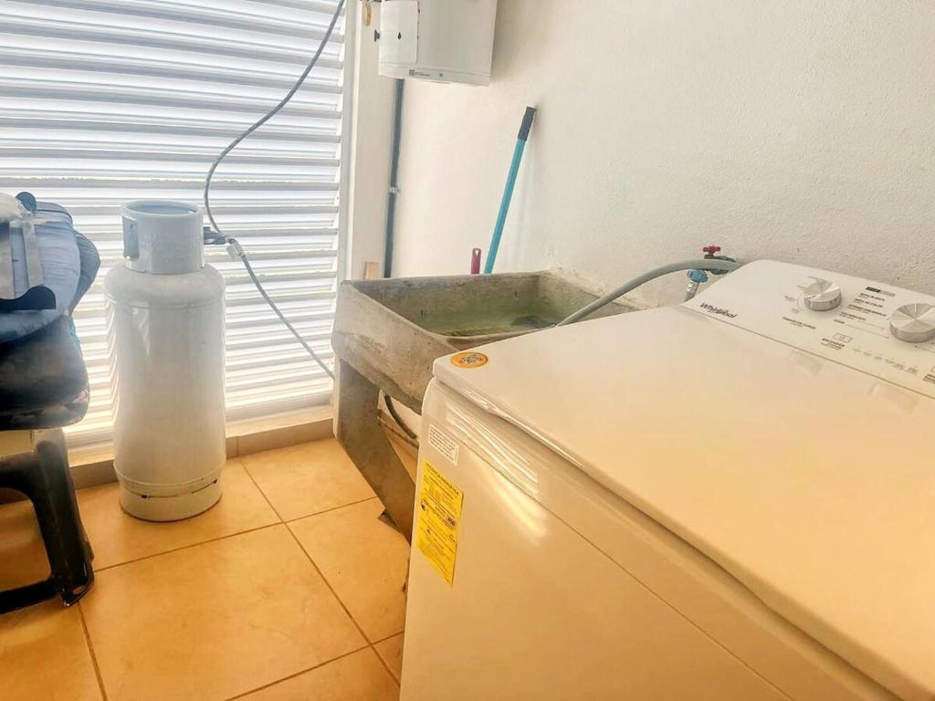 cocina con nevera y botella de agua en Departamento Zona Diamante, en Barra Vieja