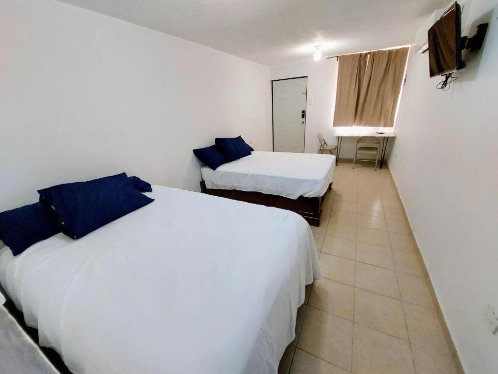 Una habitación de hotel con dos camas y una ventana. en Departamento 1 cerca del CAS y consulado,CRIT,Centro de Gobierno y Galerías Mall Cómodo, moderno y con entrada autónoma, en Hermosillo