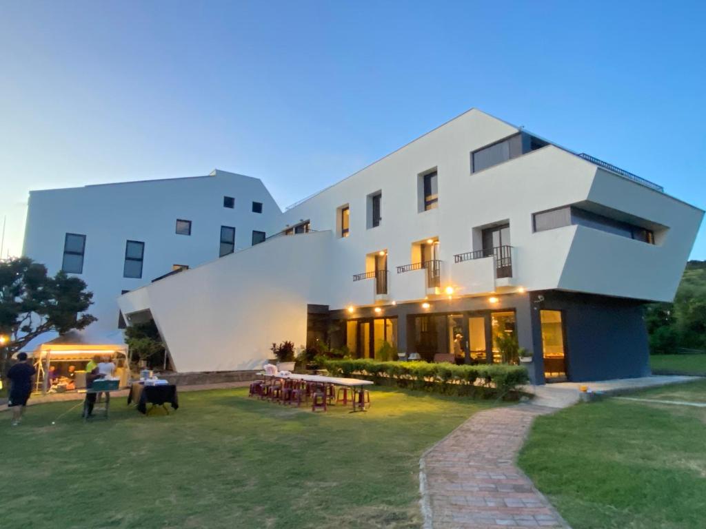 a large white building with people standing outside of it at Wangan 175 B&B in Shui-wa-chüeh