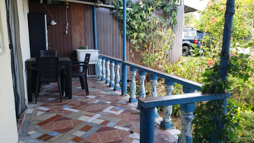a porch with a blue railing and a table at Lovely Flower Garden Apartment in Alto Boquete