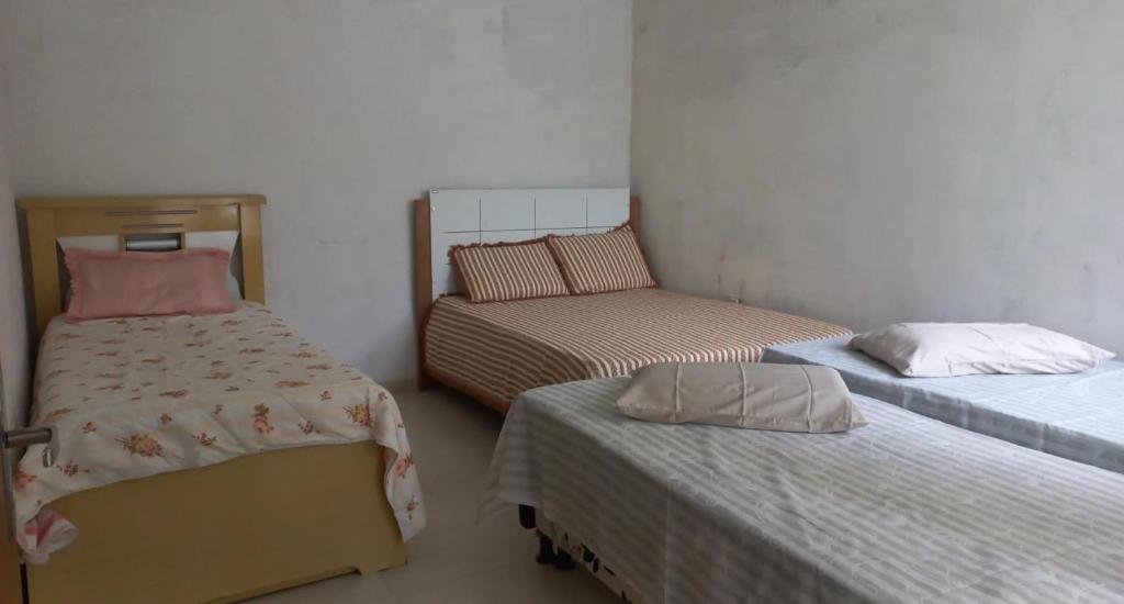 a room with two twin beds and a small bed at Casa - Aluguel por temporada in Garanhuns