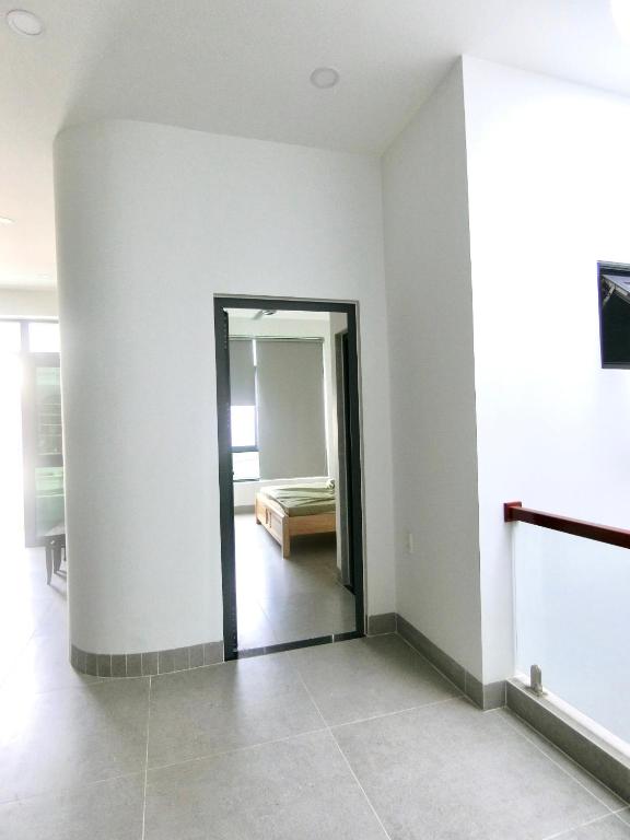 a room with a door leading to a bedroom at Luan Hoa Homestay in Ấp Bình Hưng