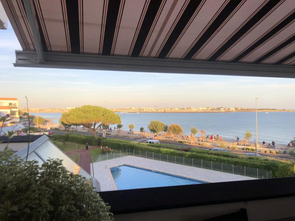 - une vue sur l'eau depuis le balcon d'un bâtiment dans l'établissement Appartement moderne avec terrasse et vue mer - La Rochelle - FR-1-535-47, à La Rochelle