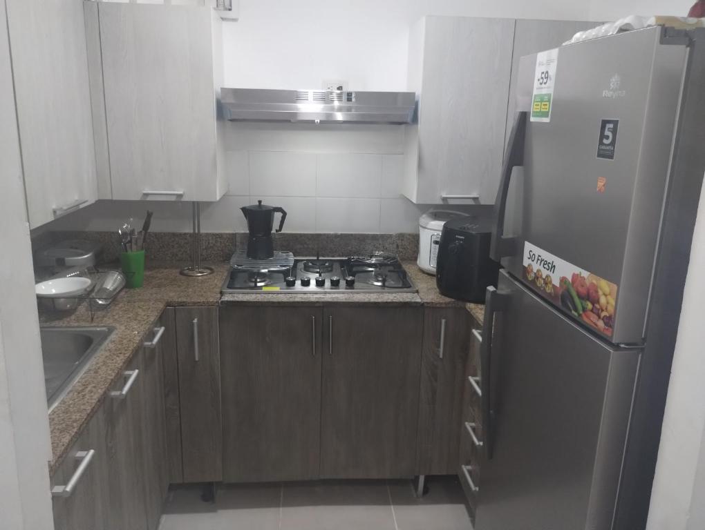 a kitchen with a stove and a refrigerator at Cómodo Apartamento en Santiago in Santiago de los Caballeros