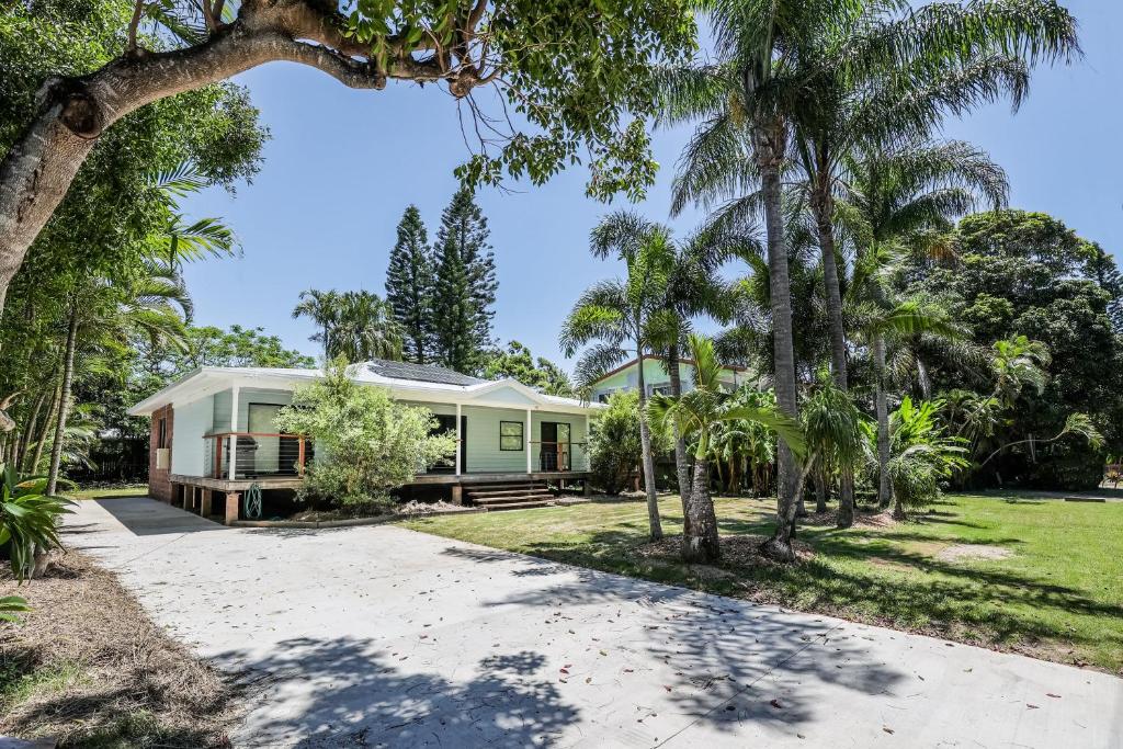 a house with palm trees in front of it at Ocean Haze - Prime Beachfront Getaway in Agnes Water