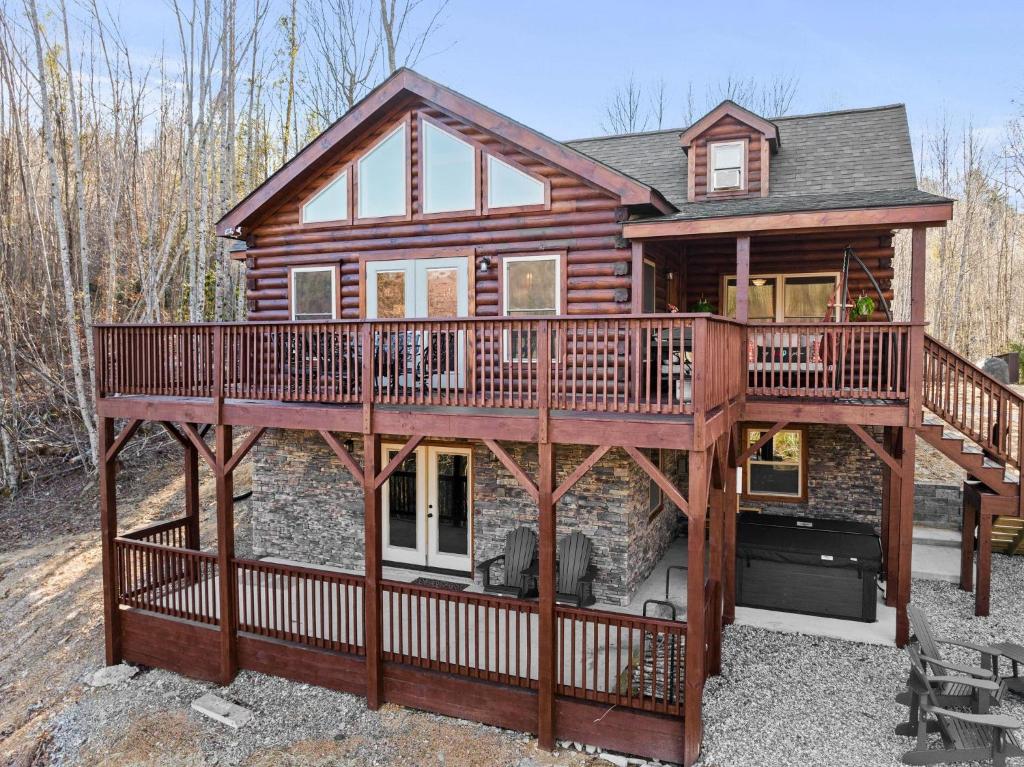 a log cabin with a deck and a balcony at Woodlake Log Cabin in Elk Park