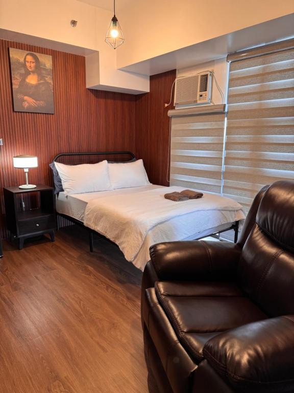 una piccola stanza con un letto e un divano di Condo in Mckinley Hill Taguig a Manila