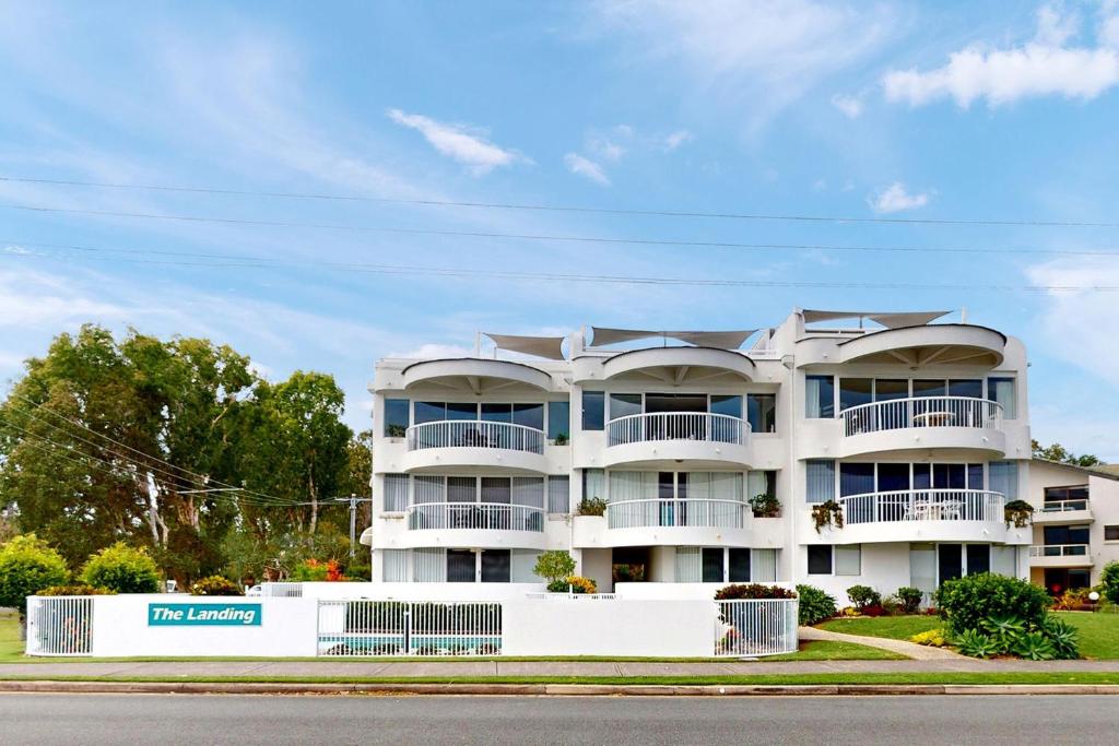 a large white apartment building with balconies on a street at 6 The Landing in Noosaville