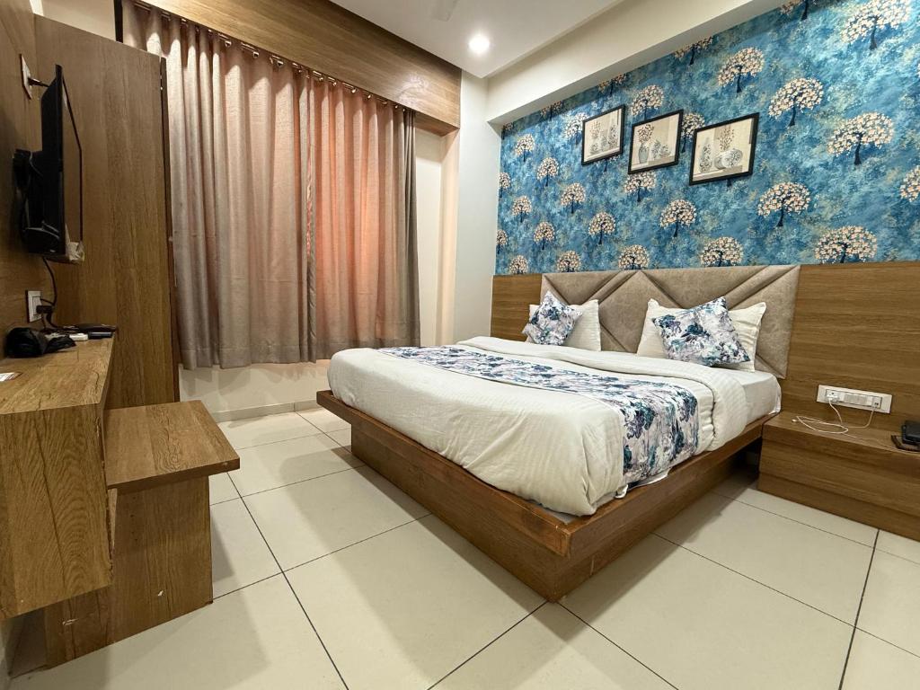 a bedroom with a bed and a blue wall at Hotelsuncity inn in Vadodara