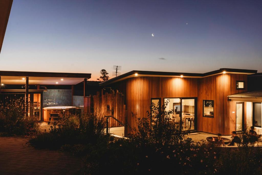 a large house with wooden walls and windows at night at Hollyberry House in Cooma