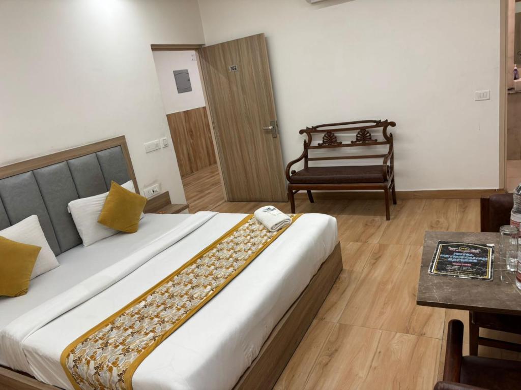 a bedroom with a large bed and a chair at Metropolitan Inn IGI Airport New Delhi in New Delhi