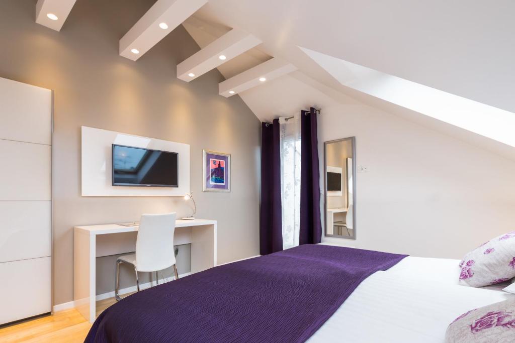a bedroom with a bed and a desk with a tv at Laura Lux Suites in Split